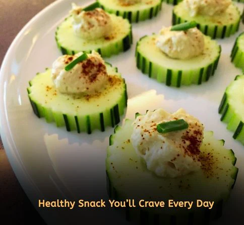 Creamy hummus served with fresh cucumber slices on a wooden board for a healthy low calorie snack recipe