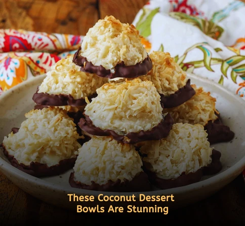 Coconut macaroon bowls filled with fresh raspberries on a picnic style serving table