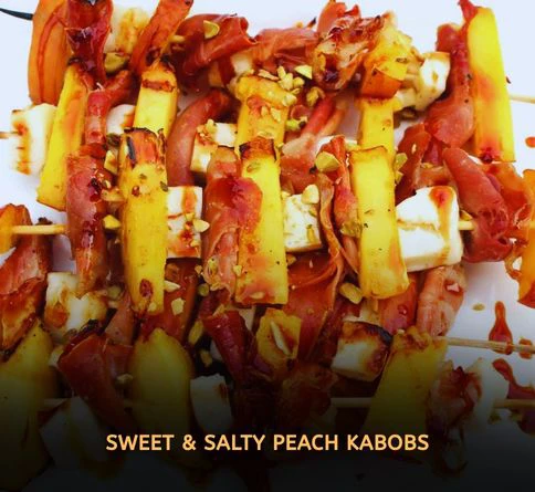 Grilled peach and prosciutto skewers drizzled with honey on serving platter