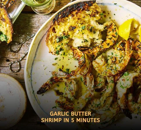 Grilled garlic butter shrimp skewers cooking over open flames with smoky char marks and fresh herbs on an outdoor summer grill.