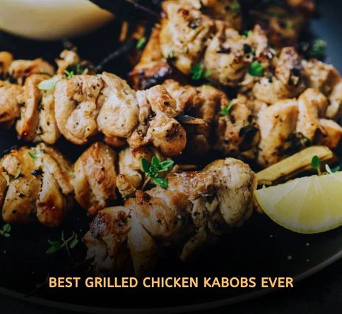 Lemon herb chicken kabobs grilling with fresh herbs and golden char marks on outdoor barbecue