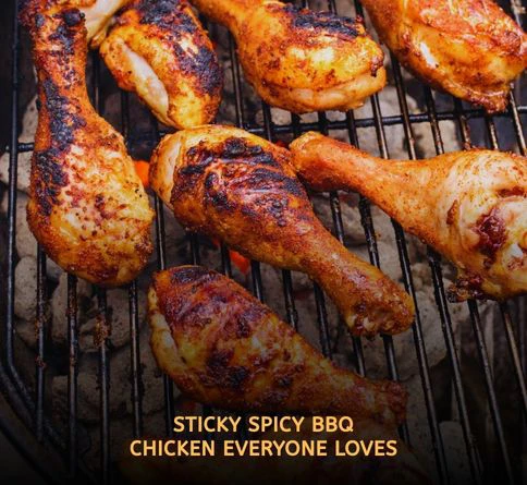 Sticky spicy BBQ chicken drumsticks glazed with sauce and grilling over flames at a backyard summer barbecue party.