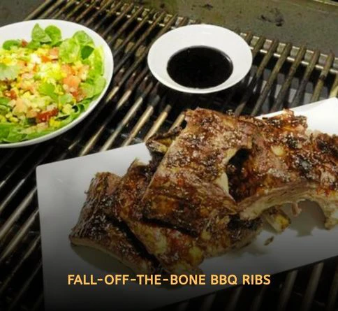 Sticky honey glazed pork ribs caramelizing on a smoky outdoor grill with rich barbecue sauce and charred edges.