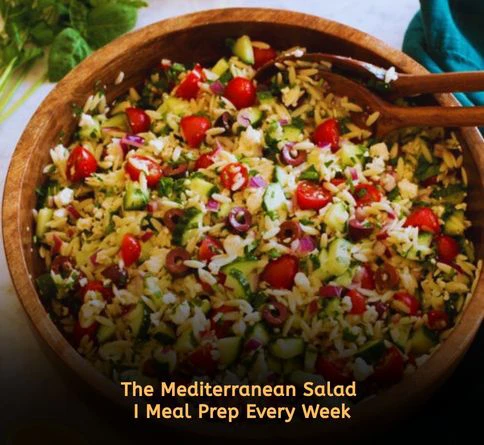 Greek orzo salad with feta cheese, olives, cucumber, and lemon dressing in a serving bowl