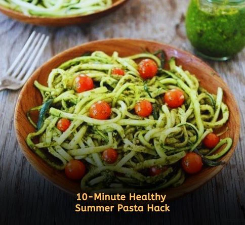 Zucchini noodles tossed with pesto and cherry tomatoes in a healthy summer pasta bowl