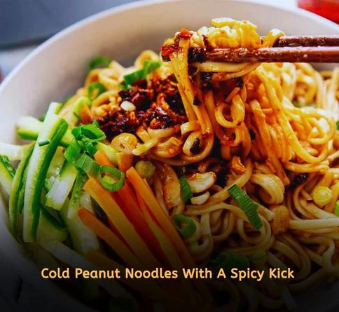 Spicy peanut cold noodles topped with chopped peanuts and fresh vegetables in a bowl