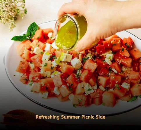 Watermelon feta salad with mint leaves and lime dressing in a picnic setting.