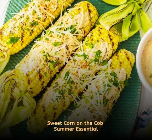 Butter-coated corn on the cob served at a family picnic outdoors