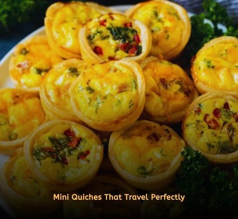 Golden mini quiches with spinach, cheese, and bacon served on a picnic blanket outdoors.