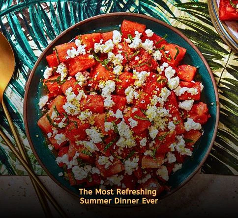 Watermelon feta salad with mint leaves and fresh lime in a large serving bowl.