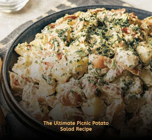 Creamy homemade potato salad in a serving bowl at an outdoor picnic table