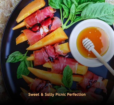 Fresh cantaloupe wedges wrapped with prosciutto for an elegant outdoor picnic snack.