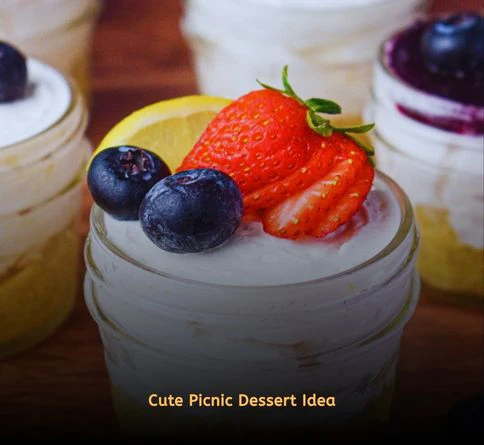 Mini cheesecake jars topped with cherry filling for a romantic outdoor meal.