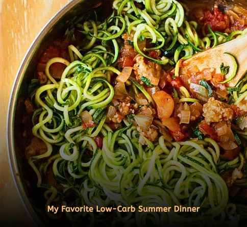 Zucchini noodles tossed with marinara sauce in a skillet for a healthy low-carb summer meal.