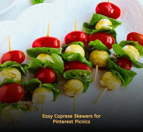 Caprese skewers with cherry tomatoes, mozzarella balls, basil leaves, and balsamic glaze on a picnic table.