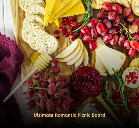 Artisan charcuterie board with cheeses, salami, grapes, olives, and crackers outdoors.
