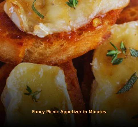 Warm baked brie cheese served with crostini, honey drizzle, and walnuts at an outdoor picnic.