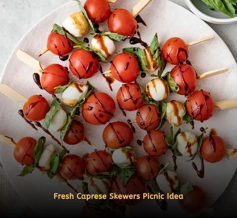 Tomato mozzarella basil skewers on picnic plate