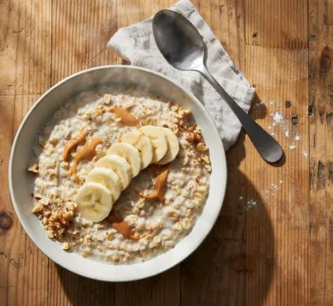 Oatmeal Bowl of oatmeal with banana slices, a complex-carb pre-workout meal
