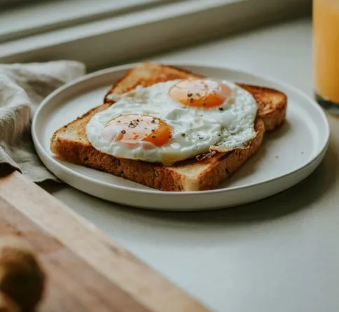 Whole Wheat Toast with Eggs Whole wheat toast with fried egg, a balanced pre-workout breakfast
