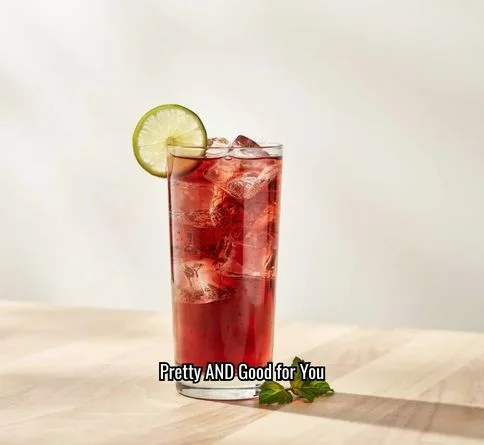 Deep red hibiscus iced tea sparkler with a lime wheel garnish