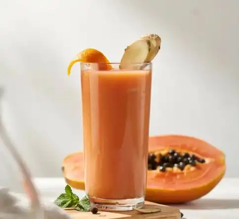 Papaya orange ginger smoothie recipe garnished with fresh ginger and orange