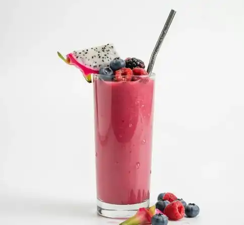 Bright pink dragon fruit and mixed berry smoothie recipe in a clear glass
