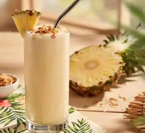 Healthy tropical smoothie with pineapple, coconut, and toasted coconut flakes