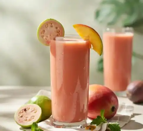 Guava mango tropical smoothie recipe garnished with fresh guava and mango
