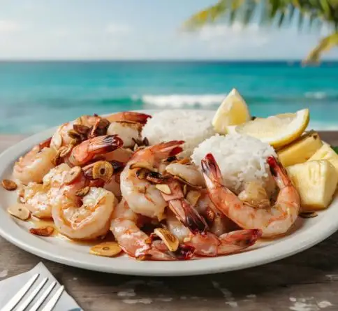 Hawaiian garlic butter shrimp served with steamed rice and lemon on an island-style plate.