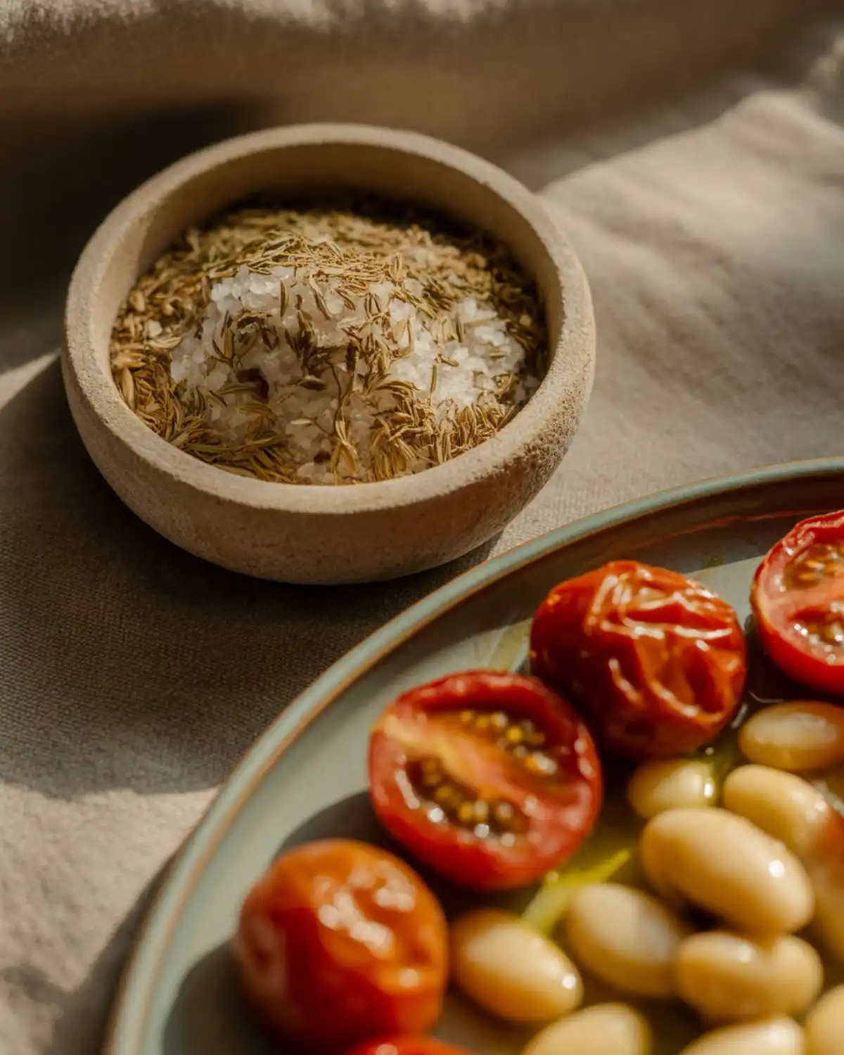 Fennel basil salt with crushed fennel seeds, roasted tomatoes, and white beans.