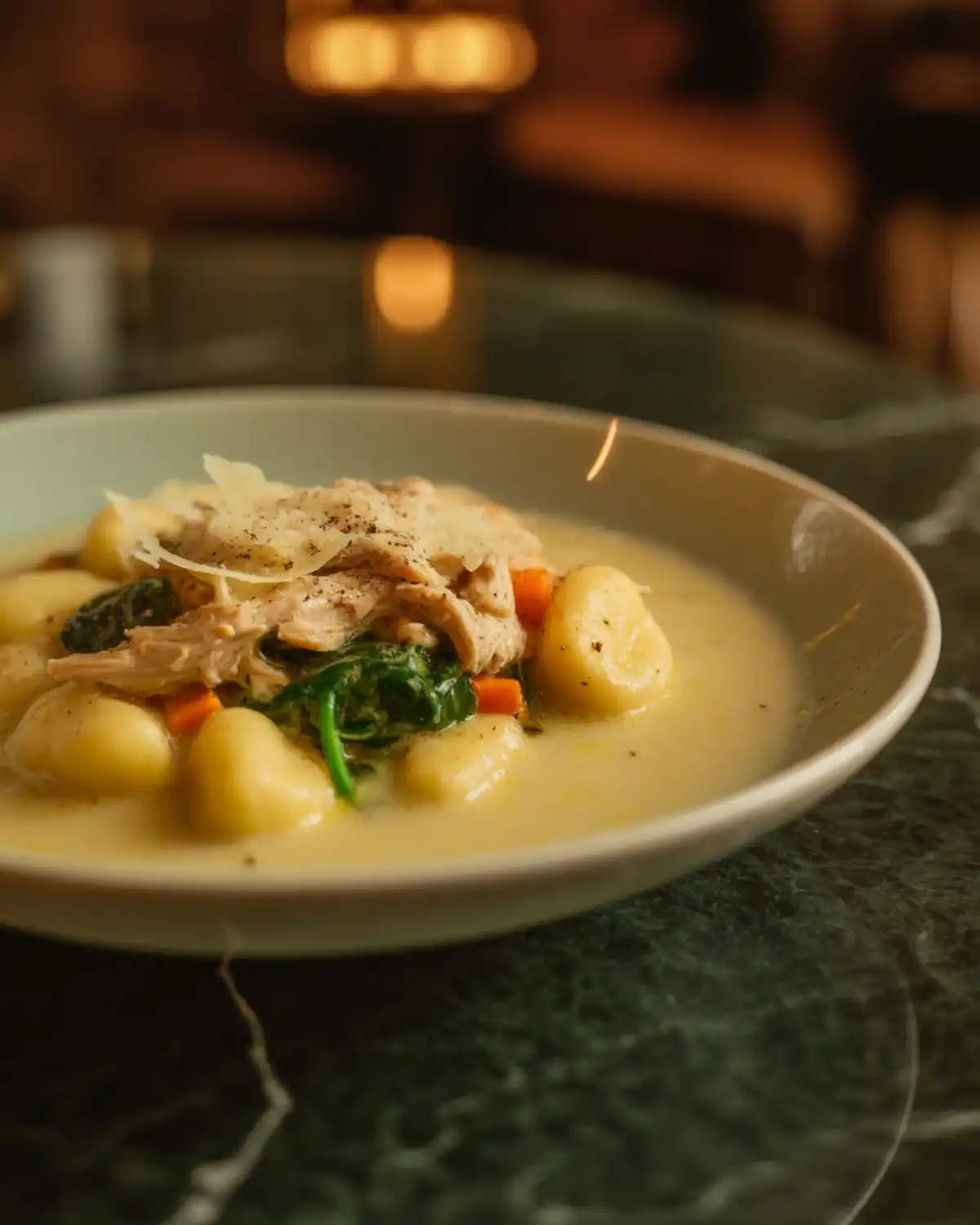 Creamy chicken gnocchi soup with tender gnocchi, chicken, spinach, carrots, and black pepper.
